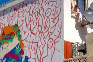 A woman looks on from her window next to a mural by Moroccan street artist Omar Lhamzi. By FADEL SENNA (AFP)