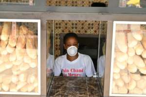 A woman wears a mask at a bakery in Azaguie-Ahoua. By ISSOUF SANOGO (AFP)