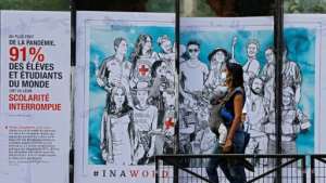 A woman with her baby walks past a street art poster created by the French artist Combo for the International Committee of the Red Cross in Paris. By THOMAS COEX (AFP/File)