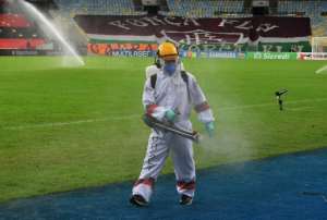 A worker disinfects the pitch at half time during the Rio de Janeiro state championship football final match between Flamengo and Fluminense at Maracana stadium, Rio de Janeiro, Brazil on July 15, 2020. By CARL DE SOUZA (AFP)