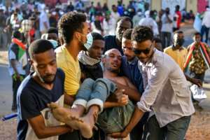 A wounded Sudanese anti-coup protester is carried away during a demonstration in the capital's twin city of Omdurman. By - (AFP)