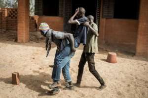 A young homeless man believed to be suffering from malnutrition is carried to a clinic. The pandemic has been catastrophic for Dakar's rough sleepers, inflicting stigma, fewer food donations and loss of money from begging. By JOHN WESSELS (AFP)