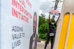 A youth holds up a sign reading