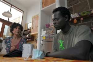 Adelina Abdola decided to offer a roof to homeless migrants and is currently hosting Ousmane, a fisherman from Senegal who is learning Spanish and wants to train as a mechanic, carpenter or welder. By LLUIS GENE (AFP)