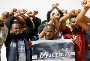 African migrants protest on February 22, 2018 outside the Saharonim Prison, where at least nine others have been incarcerated as part of Israel's policy of prison or deportation for migrants.  By MENAHEM KAHANA (AFP)