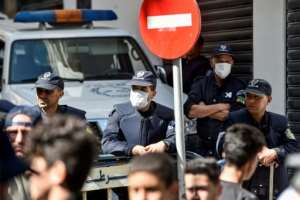 Algerian anti-riot police wear protective masks as protesters march during an anti-government demonstration in the capital Algiers on March 6. By RYAD KRAMDI (AFP/File)