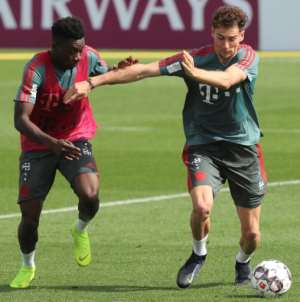 Alphonso Davies (L) spars with Germany midfielder Leon Goretzka (R) during a training session with Bayern Munich in Doha..  By KARIM JAAFAR (AFP)