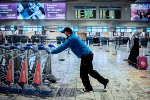 An airport employee wears a face mask as a preventive measure against the COVID-19 coronavirus at the O.R. Tambo international airport in Johannesburg. By Luca Sola (AFP)