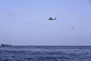An airplane drops flotation devices as migrants wait to be rescued in the Mediterranean Sea off the coast of Libya on October 4, 2016