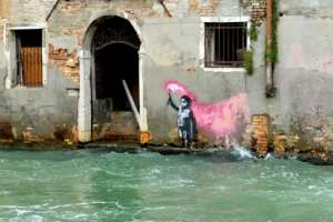 An alleged work by British street artist Banksy depicting a migrant child wearing a lifejacket holding a pink flare is painted on the outer wall of a house in Venice. By Marco SABADIN (AFP/File)