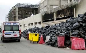 An ambulance drives along a street in Tunisia's second city of Sfax where stinking garbage has piled up since late September after a main landfill in the region was closed. By HOUSSEM ZOUARI (AFP)