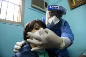 An Egyptian doctor adjusts the protective mask covering a young patient's face at the infectious diseases unit of a Cairo hospital. By Ahmed HASAN (AFP/File)
