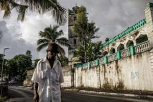 An elderly resident walks past a mosque in downtown Moroni. The grind of poverty in the Comoros can be worsened by comparisons with Mayotte, the island that chose to remain under French rule. By GIANLUIGI GUERCIA (AFP)