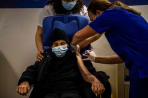 An elderly woman receives a vaccine in Greece. By ANGELOS TZORTZINIS (AFP)