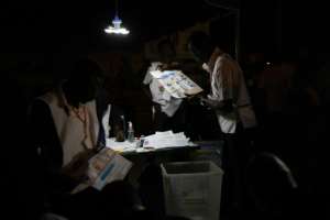 An electoral commission official holds a ballot during the counting of votes at a polling station during the Burkina Faso presidential and legislative elections on November 22, 2020 in Ouagadougou.  By OLYMPIA DE MAISMONT (AFP / Archive)