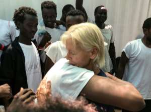 An MSF nurse joins the migrants to celebrate. By Anne CHAON (AFP)