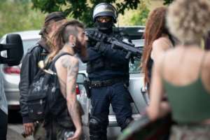 An officer looks on as police evacuate partygoers after an illegal rave in a field in Redon, France. By LOIC VENANCE (AFP)