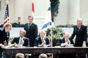 Anwar Sadat (left) and Menachem Begin (right) signing the Israel-Egypt Peace Treaty in Washington in the presence of Jimmy Carter (centre) on March 26, 1979.  By - (FILES-CONSOLIDATED NEWS PICTURES/AFP/File)