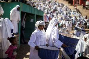Apocalypse clerics pass through the congregation to collect donations. By GIANLUIGI GUERCIA (AFP)