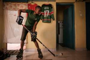 Benjamin Mburu, a Kenyan hockey player, practices stick work in his living room in Nairobi, Kenya, on May 19, 2020, with all training suspended by lockdowns. By Yasuyoshi CHIBA (AFP)