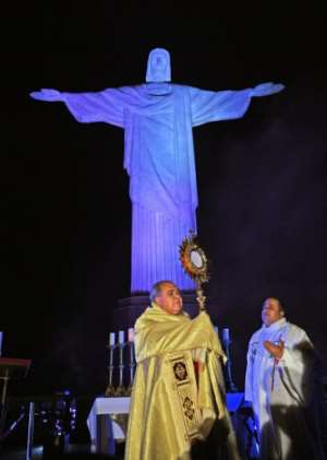 Brazilian Archbishop Cardinal Dom Orani celebrates Easter Mass at the Christ Redeemer statue in Rio de Janeiro, where the landmark had a doctor's uniform projected onto it in honour of all the medical staff worldwide fighting the coronavirus pandemic. By CARL DE SOUZA (AFP)