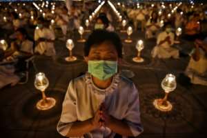 Buddhist worshippers wearing protective masks attend prayers at Wat Dhammakaya Buddhist temple in Bangkok -- Thailand has announced 14 confirmed coronavirus infections. By Lillian SUWANRUMPHA (AFP)
