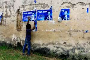 Cameroonian President Paul Biya, seen here in posters, vowed address needs of anglophone areas, but the conflict continues. By STR (AFP)