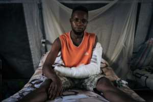 Casualty: A young man who was shot in the arm in an attack on his village north of Beni. By ALEXIS HUGUET (AFP)