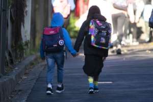Children make their way to school in Wellington, New Zealand, after the government allowed schools to re-open under its guidelines. By Marty MELVILLE (AFP)