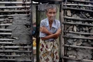 Chill: A displaced woman, shivering from the cold, in the doorframe of a house in Beira. By EMIDIO JOSINE (AFP)