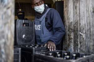 Confiscated: Crates of beer join other suspected stolen goods that police haul away from the hostel. By MARCO LONGARI (AFP)