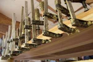 Clamps hold a wooden strip in place to make the all-important 'rail' (edge) of a surfboard in Burnett's workshop. By RODGER BOSCH (AFP)