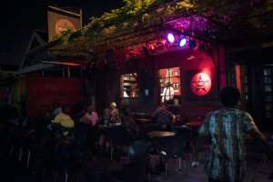 Customers sit outside the Republic Bar & Grill, one of the most well-known pubs in Accra and popular for its cocktails.  By CRISTINA ALDEHUELA (AFP)