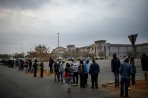 Customers queue while waiting for the opening of a liquor shop in Lenasia, Johannesburg, on Tuesday. By Michele Spatari (AFP)