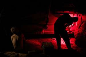 Dangerous land: British army mechanics from MINUSMA'S Long Range Reconnaissance Group repair Foxhound armoured vehicles at night in the desert. They work in red light to try to avoid drawing enemy fire. By FLORENT VERGNES (AFP)