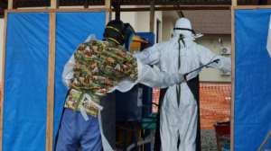 Doctors coming out of the red zone at the Intensive Care Unit (ICU) are carefully disinfected by hygienists at the 14 Military Hospital in Monrovia, Liberia. By Zoom DOSSO (AFP)