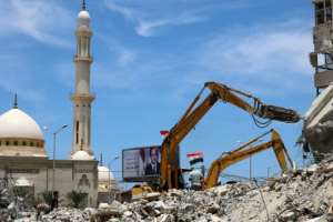 Egyptian workers use bulldozers to remove the rubble of Gaza City buildings destroyed by Israeli air strikes in this picture taken on June 8, 2021. By MOHAMMED ABED (AFP)