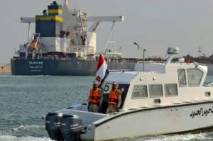 Egyptian coast guards patrol as a ship navigates the newly reopened Suez Canal after a near week-long blockage. By Tarek WAJEH (AFP)