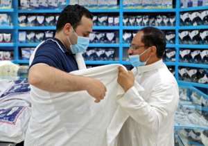 Egyptian Mohammed Alatar tries on the simple garment worn by pilgrims performing the hajj at a store in Saudi Arabia. By FAYEZ NURELDINE (AFP)