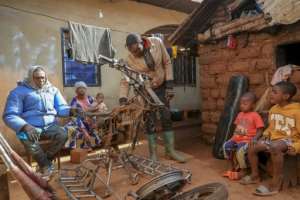 Emmanuel Wembe, centre, gets to work customising a motorbike for heavy duty. By Daniel Beloumou Olomo (AFP)