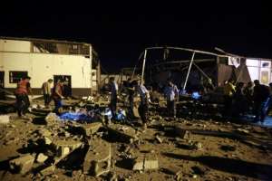 Emergency workers recover bodies after an air strike that targeted a migrant centre in a suburb of the Libyan capital and killed dozens. By Mahmud TURKIA (AFP)