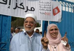 Ennahdha's presidential candidate Abdelfattah Mourou and his wife show their ink-stained fingers after casting their votes on the outskirts of the capital Tunis. By Fethi Belaid (AFP)