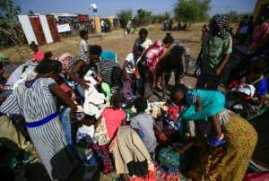 Ethiopian refugees pick through clothing aid at the 'Village 8' reception center. By ASHRAF SHAZLY (AFP)