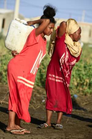 Ethiopian women who fled fighting in Tigray carry water containers at the 'Village 8' facility in Sudan's eastern Gedaref state. By ASHRAF SHAZLY (AFP)