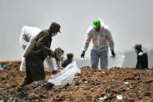 Forensic experts comb through the dirt for debris at the crash site of the Ethiopian Airlines Boeing 737 MAX 8 aircraft. By TONY KARUMBA (AFP)