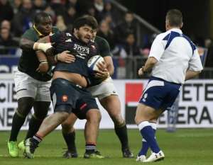 France's prop Sébastien Taofifenua (C) is tackled during their match against South Africa's Springboks in Saint-Denis, on the outskirts of Paris, on November 18, 2017