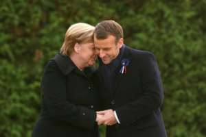 French President Emmanuel Macron and German Chancellor Angela Merkel hold hands after unveiling a plaque in a French-German ceremony in the clearing of Rethondes (the Glade of the Armistice) in Compiegne, northern France.  By PHILIPPE WOJAZER (POOL/AFP)