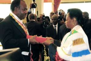 Gabon's Constitutional Court President Marie Madeleine Mborantsuo hands the Gabonese constitution to Ali Bongo Ondimba, after he was sworn in as president in 2009