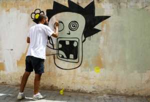 Graffiti artist Kaisser Grojja, also known as 'Wolf Gang', works on a mural in Sidi Bouzid in central Tunisia. By ANIS MILI (AFP)