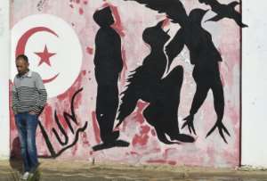 A graffiti represents a man transforming into a bird symbolizing freedom, on the Mohamed Bouazizi square - named after the street vendor who started the revolution - in the city of Sidi Bouzid.  By Fethi Belaid (AFP / File)